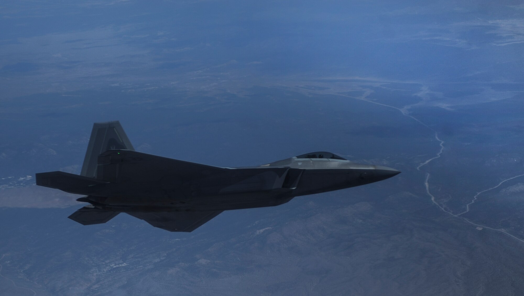 An F-22A Raptor, assigned to the 27th Fighter Squadron, Joint Base Langley-Eustis, Va., banks over the Nevada Test and Training Range, during Red Flag 16-3, July 27, 2016. All four branches of the U.S. Military participate in the Red Flag training conducted on the vast bombing and gunnery ranges of the Nevada Test and Training Range. (U.S. Air Force photo by Airman 1st Class Kevin Tanenbaum/Released)