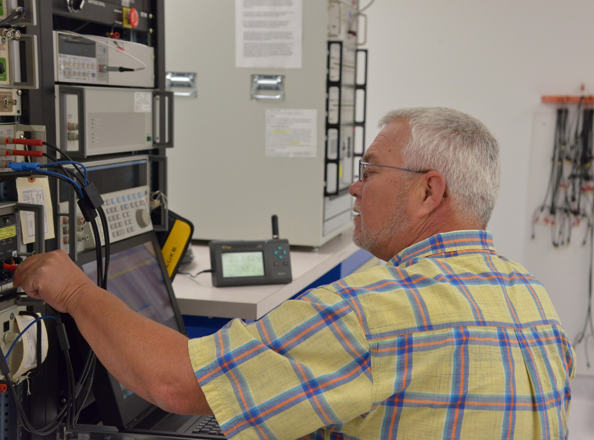 Dave Jinks, a technician in the Kirtland Precision Measurement Equipment Laboratory, uses the 10-volt base reference standard to calibrate a high-accuracy digital multimeter. (Photo by Jamie Burnett)
