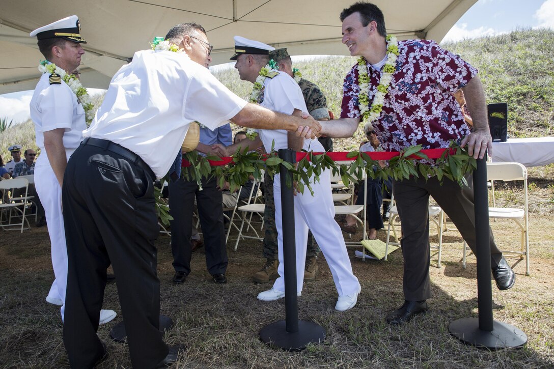MARINE CORPS BASE HAWAII – Joseph Bryan, the deputy assistant secretary of the Navy for Energy, and a Cleveland, Ohio, native, thanks Kahu Sherman Thompson, a Hawaiian minister, and a Honolulu native, after a blessing ceremony for the Wave Energy test Site near the French Battery bunker aboard Marine Corps Base Hawaii, July 26, 2016. Bryan oversees Department of the Navy policies on matters pertaining to operational and shore energy initiatives for the Secretary of the Navy. The area was blessed by a Hawaiian minister to protect the Wave Energy Conversion devices and the staff that work on them. The WEC devices harness the energy from the oceans waves, an abundant and renewable energy. The WEC devices near the base are currently in the prototype stage, but with more research and development can help provide electricity to impoverished coastal cities and military installations. (Marine Corps Photo by Lance Cpl. Jesus Sepulveda Torres)