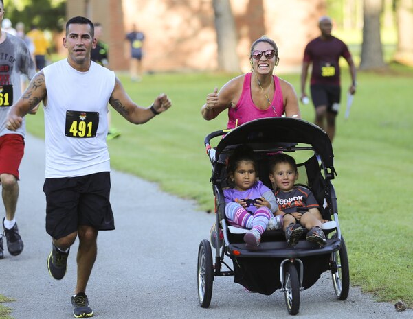 Junior Figuerda, left, and Carol Figuerda run through the finish line during the 7.5K Anniversary Run aboard Marine Corps Air Station Cherry Point, N.C., July 29, 2016. The run was to celebrate the 75th anniversary of MCAS Cherry Point and 2nd Marine Aircraft Wing.  (Marine Corps photo by Lance Cpl. Cody Lemons/ Released) 