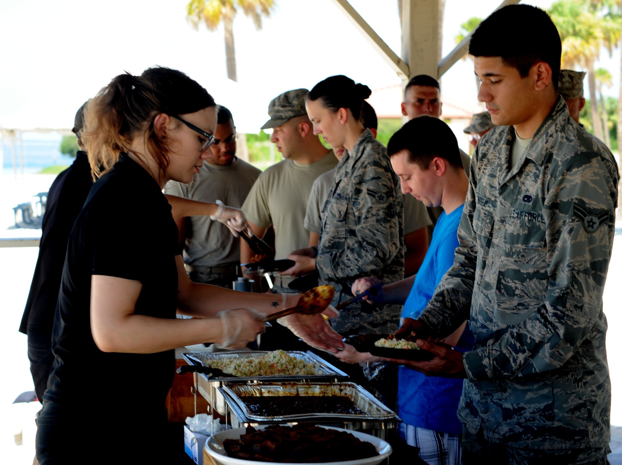 MacDill dormitory residents receive catered food during the Dorm Summer Bash at MacDill Air Force Base, Fla., July 27, 2016. The Bash was held by the First Sergeants Council and the 5/6 Council for MacDill dorm residents as a way for them to relax and have fun at the beach. (U.S. Air Force photo by Airman Adam R. Shanks)