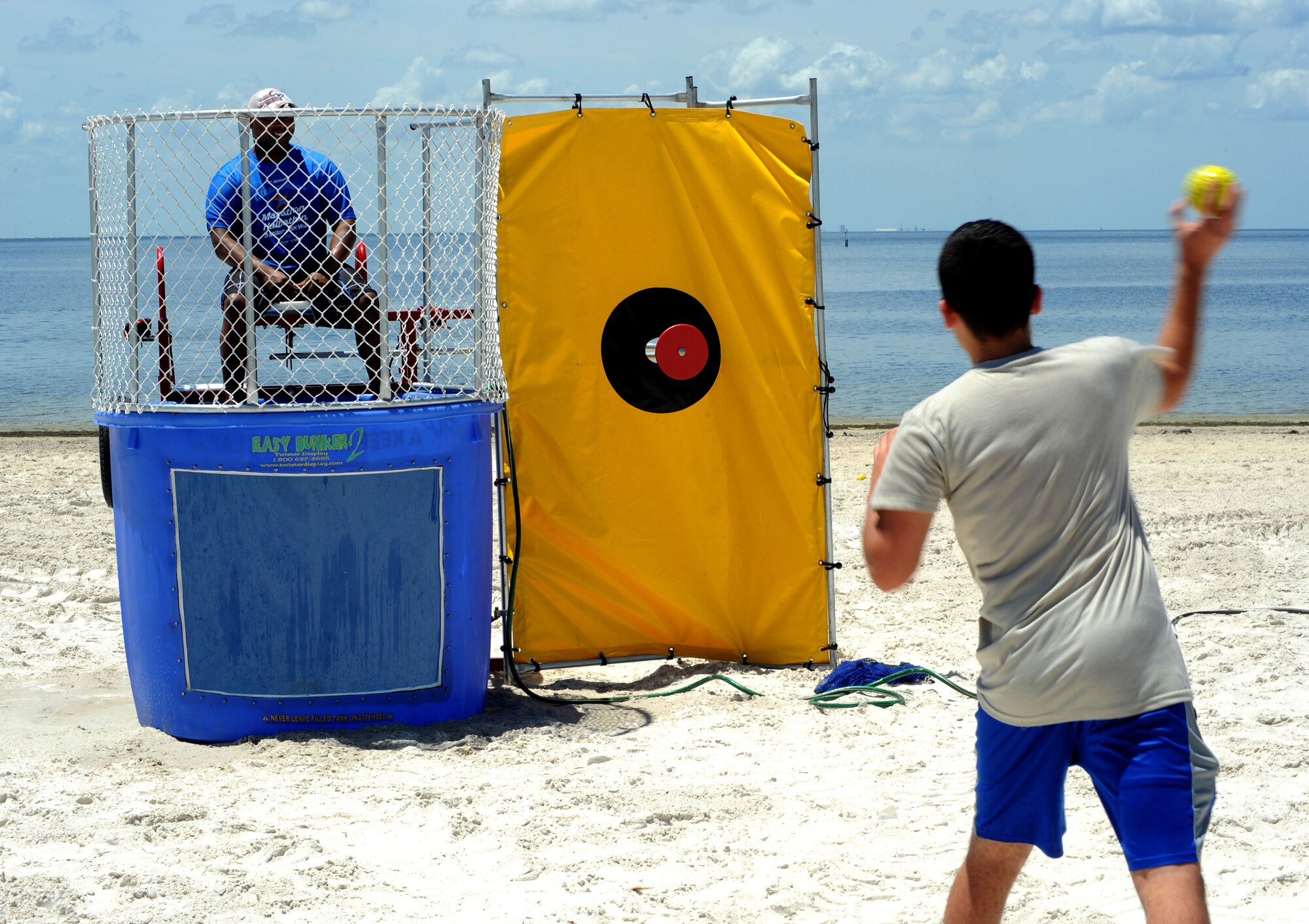 An Airman attempts to dunk Master Sgt. Chris Sheppard, first sergeant assigned to the 6th Maintenance Squadron, in a dunk tank during the Dorm Summer Bash at MacDill Air Force Base, Fla., July 27, 2016. MacDill dormitory residents were able to enjoy food, music, and games with first sergeants from MacDill. (U.S. Air Force photo by Airman Adam R. Shanks)