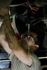 Staff Sgt. Adam Garcia, 5th Logistics Readiness Squadron vehicle maintenance technician, drains fluid from a Humvee in the Defender Dome at Minot Air Force Base, N.D., July 28, 2016. Airmen from the 5th LRS vehicle maintenance flight work to ensure that Team Minot stays mobile. (U.S. Air Force photos/Airman 1st Class J.T. Armstrong)
