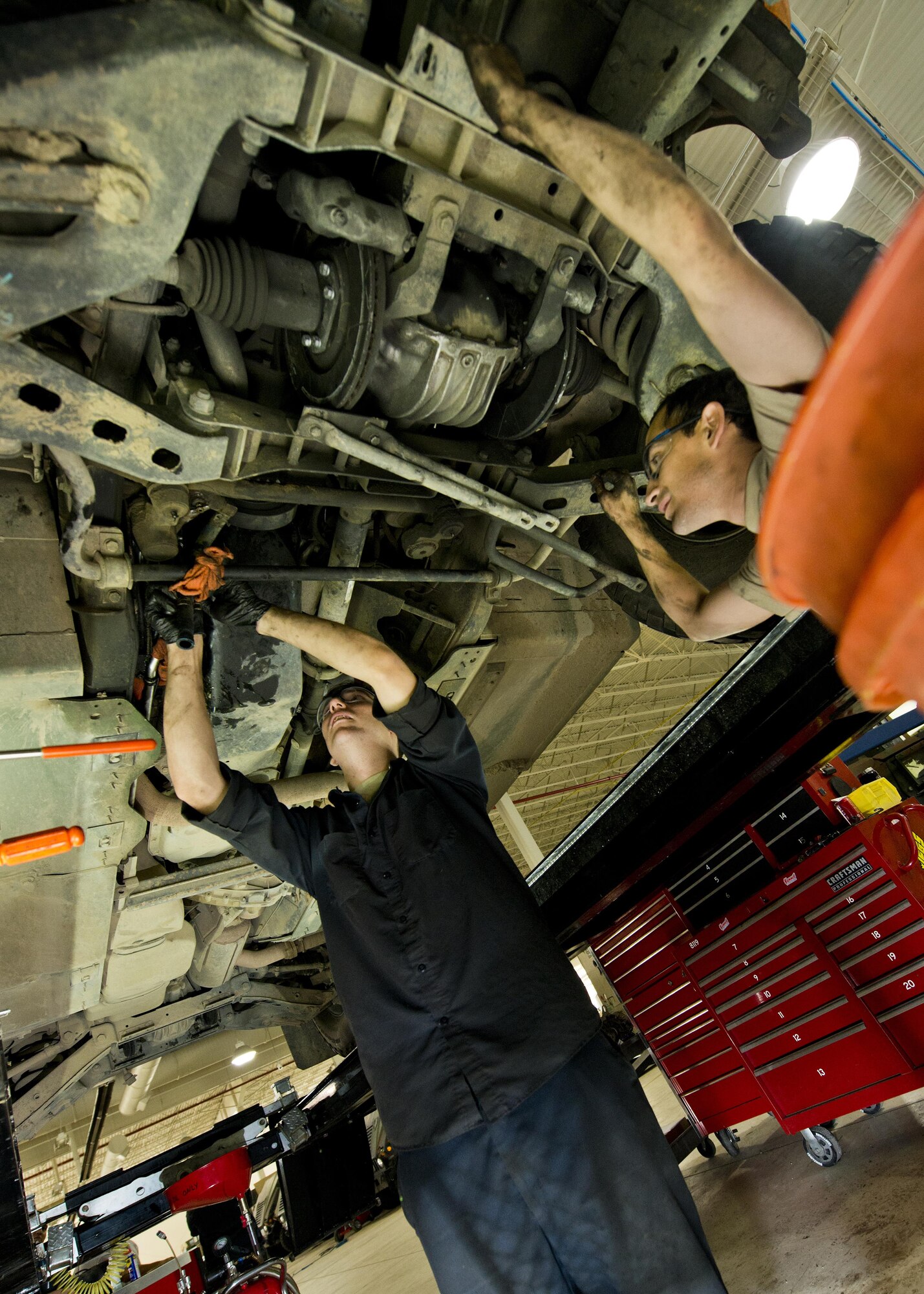 Senior Airman Logan Rivelli (left) and Staff Sgt. Adam Garcia, 5th Logistics Readiness Squadron vehicle maintenance technicians, inspect the underside of a Humvee in the Defender Dome at Minot Air Force Base, N.D., July 28, 2016. Airmen from the 5th LRS vehicle maintenance flight work to ensure that Team Minot stays mobile. (U.S. Air Force photos/Airman 1st Class J.T. Armstrong)