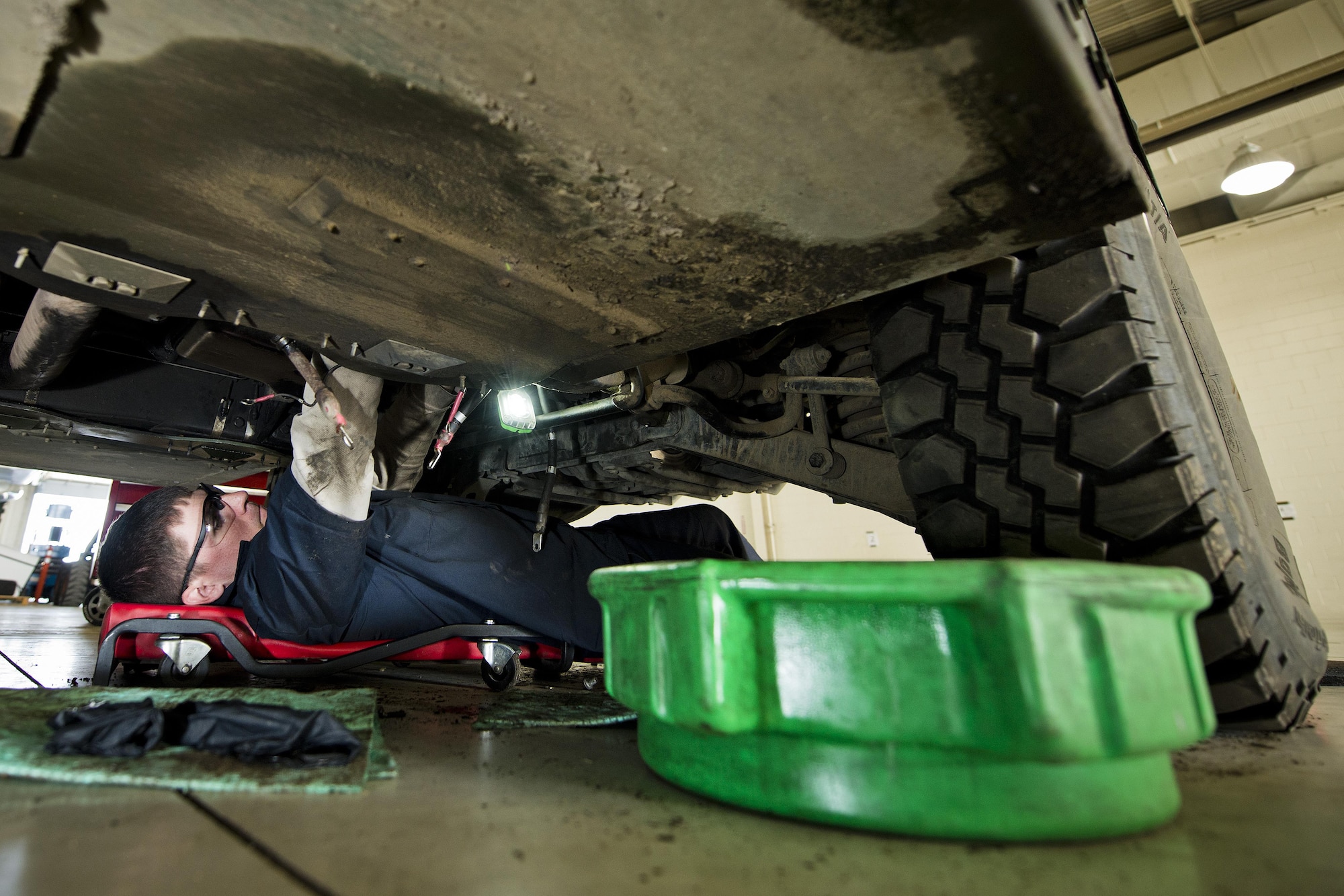 Senior Airman Brad Agner, 5th Logistics Readiness Squadron vehicle maintenance technician, works underneath a Humvee in the Defender Dome at Minot Air Force Base, N.D., July 28, 2016. Airmen from the 5th LRS vehicle maintenance flight work to ensure that Team Minot stays mobile. (U.S. Air Force photos/Airman 1st Class J.T. Armstrong)