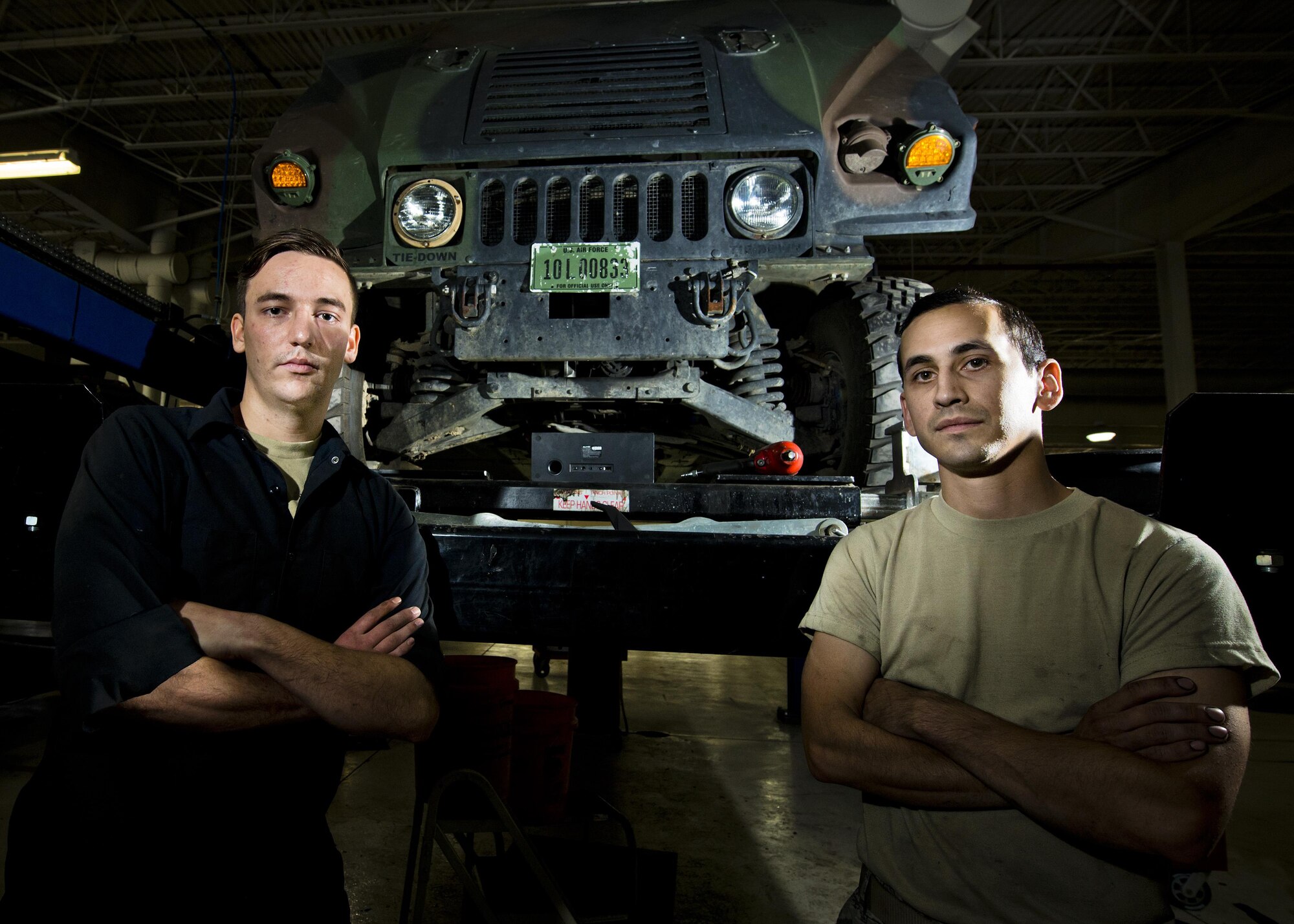 Senior Airman Logan Rivelli (left) and Staff Sgt. Adam Garcia, 5th Logistics Readiness Squadron vehicle maintenance technicians, pose for a portrait in front of a Humvee in the Defender Dome at Minot Air Force Base, N.D., July 28, 2016. Airmen from the 5th LRS vehicle maintenance flight work to ensure that Team Minot stays mobile. (U.S. Air Force photos/Airman 1st Class J.T. Armstrong)