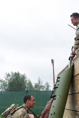 U.S. Air Force Staff Sgt. Kristopher Harpoon and Airman 1st Class Aaron Osbourne (bottom), 5th Air Support Operations Squadron, Joint Base Lewis-McChord, Wash., tactical air control party specialists (TACP), lift a simulated victim over a wall during the casuality evacuation exercise as part of Cascade Challenge July 19, 2016, at Fort Wainright, Alaska. The TACP Airmen ran through an obstacle course, rescued a casualty from a damaged vehicle, provided first-aid and evacuated the simulated casualty for the exercise. (U.S. Air Force photo by Airman Isaac Johnson)
