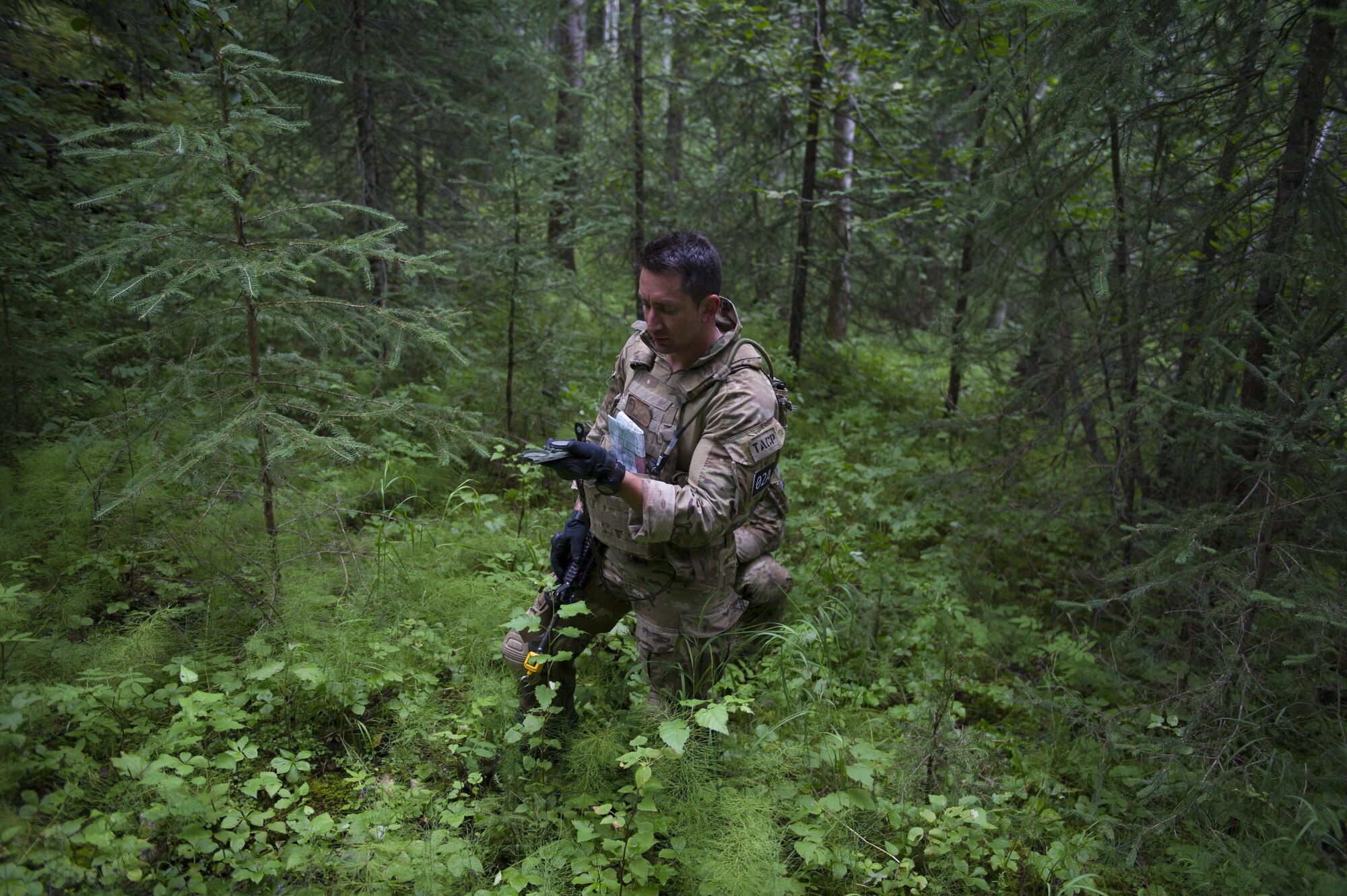 U.S. Air Force Staff Sgt. Kristopher Harpoon, a 5th Air Support Operations Squadron, Joint Base Lewis-McChord, Wash., tactical air control party specialist, checks his compass during the land navigation exercise as part of Cascade Challenge July 19, 2016, at Eielson Air Force Base, Alaska. Competitors were only allowed to use a compass to navigate to their destination. (U.S. Air Force photo by Airman Isaac Johnson)