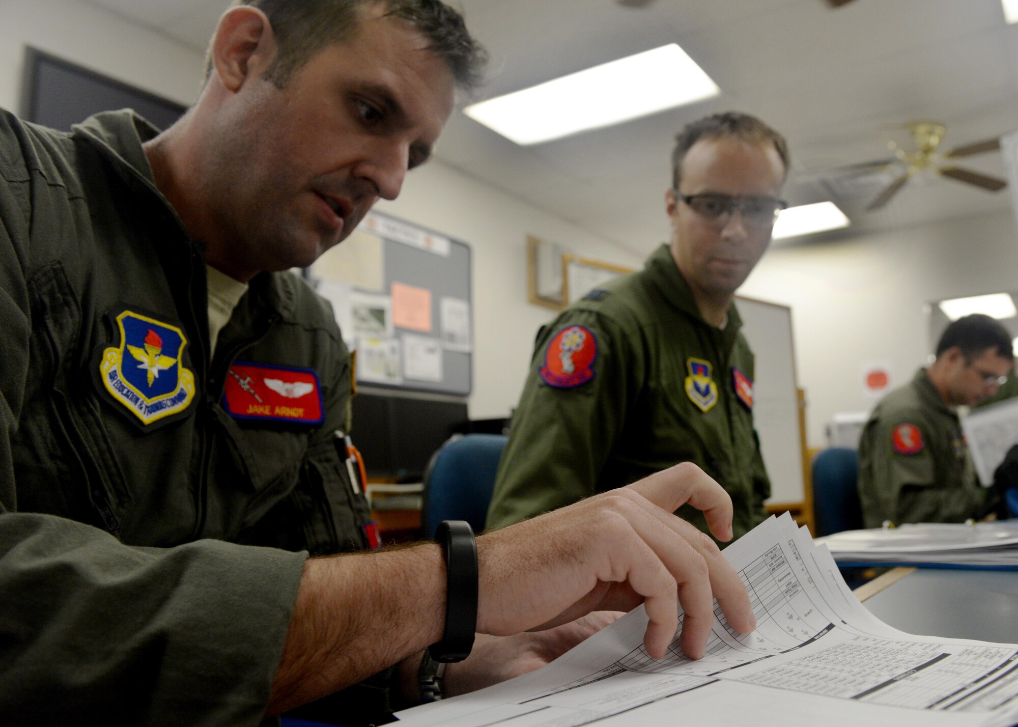 U.S. Air Force Capt. Jake Arndt, 58th Airlift Squadron instructor pilot, organizes an exercise folder July 25 2016, at Altus Air Force Base, Okla. The ALTEX is designed to test the abilities of instructors and student aircrews in the face of real world mission requirements. (U.S. Air Force Photo by Airman Jackson N. Haddon/Released).