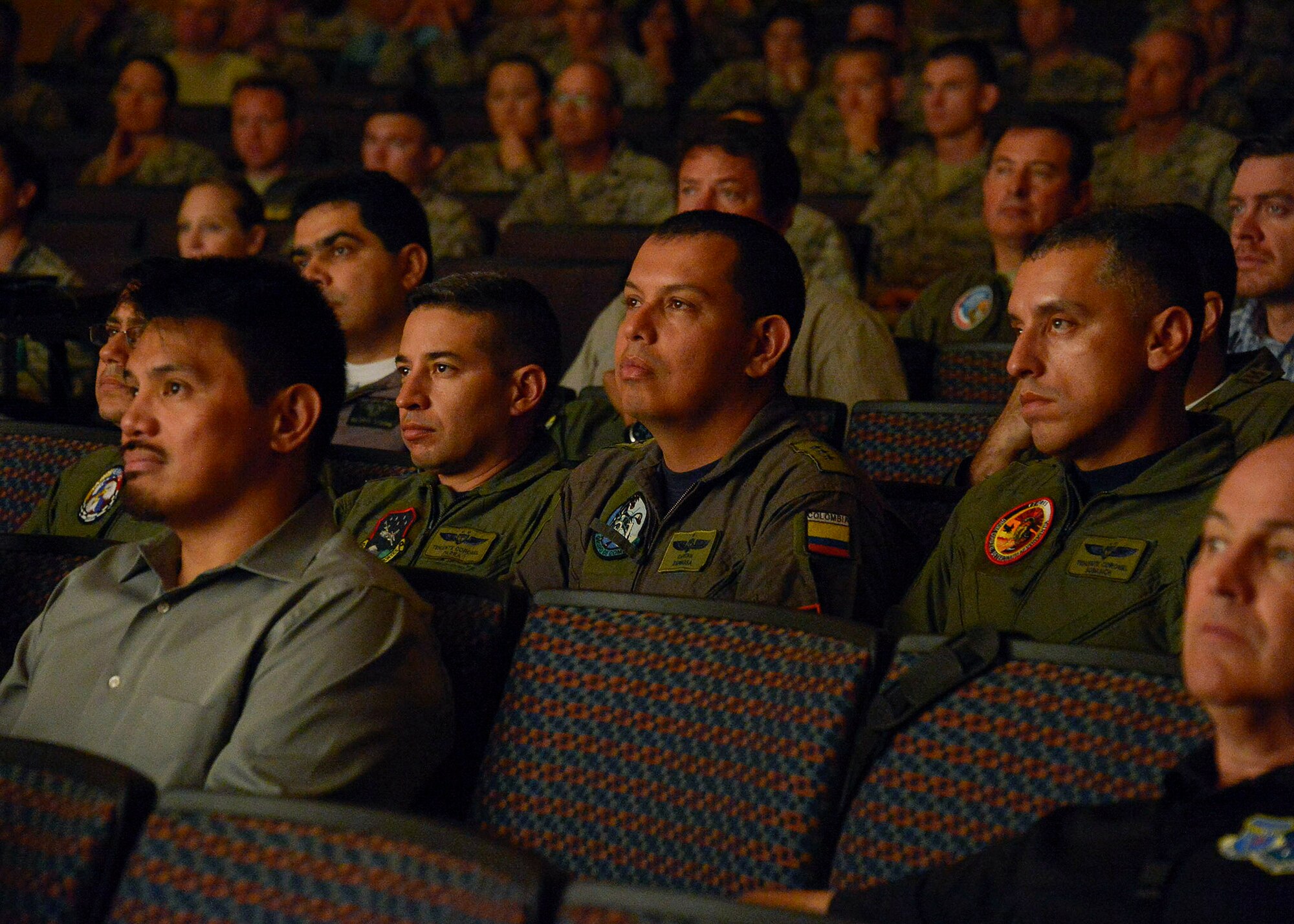 Service members from twelve different nations gather together for a briefing on the upcoming PANAMAX exercise at the base theater on Davis-Monthan AFB, Ariz., July 26, 2016. Nineteen total nations are joining the United States for a seven-day exercise that will use simulations to command and control multinational notional sea, air, cyber and land forces defending the vital waterway and surrounding areas against threats from violent extremism and to provide for humanitarian relief, as necessary. The PANAMAX exercise goal is to increase the ability of nations to work together, enable assembled forces to organize as a multination task force and test their responsiveness in combined operations. (U.S. Air Force photo by Tech. Sgt. Heather R. Redman)