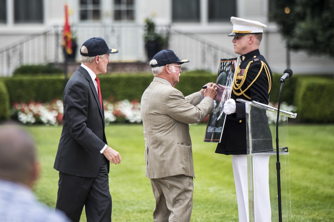 Navy Secretary Ray Mabus, left, looks on as retired Marine Corps Col. Harvey Barnum, Vietnam War Medal of Honor recipient, signs a poster of the Navy ship named after him during a ceremony at Marine Barracks Washington, D.C., July 28, 2016. The USS Harvey C. Barnum Jr. will be an Arleigh Burke-class guided-missile destroyer. DoD photo by U.S. Army Sgt. James K. McCann