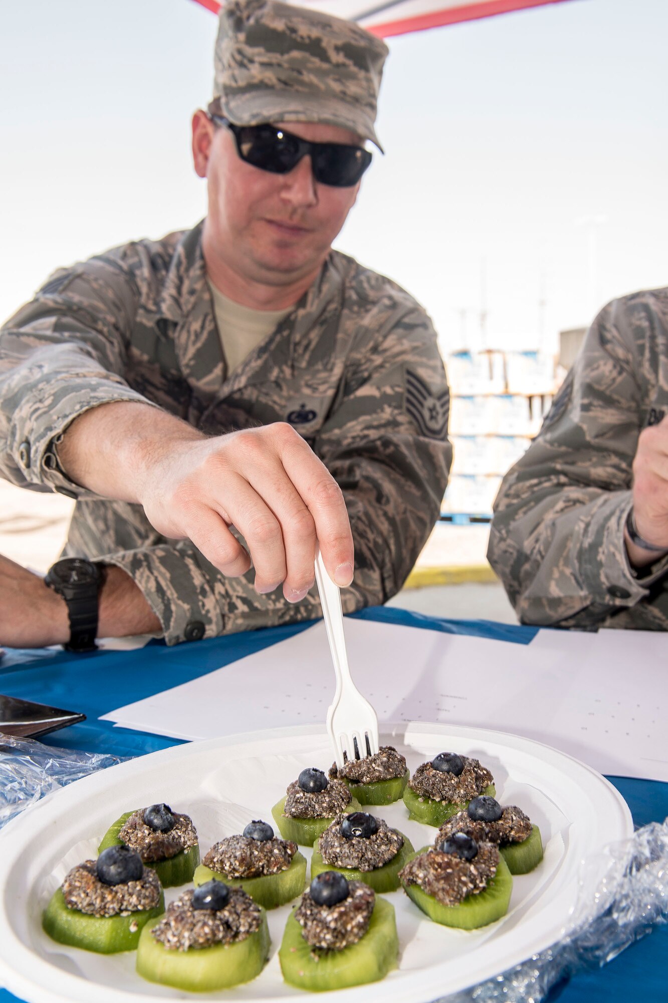 Tech. Sgt. Chris McFadden, 75th Logistics Readiness Squadron Airmen, judges a kiwi fruit snack during the ‘healthy dish’ contest July 29 at the Hill Air Force Base commissary. The annual ‘Your Healthy Lifestyle Festival’ featured discounted prices on produce at commissary farmers markets, information booths, and contests for kids and adults. (U.S. Air Force photo by Paul Holcomb)