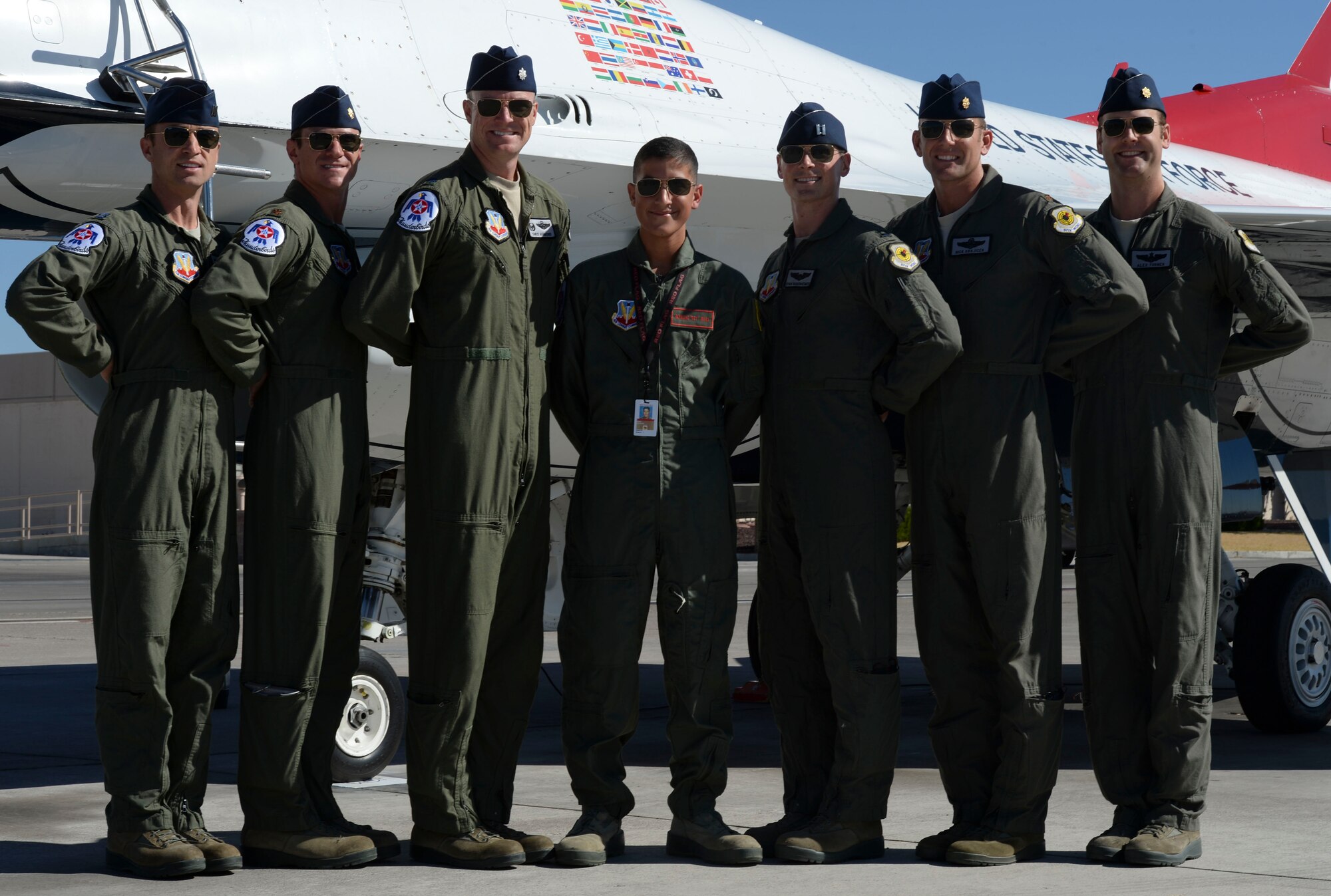 U.S. Air Force Air Demonstration Squadron pilots one through six pose for a photo with Reymond during his visit to Nellis Air Force Base, Nev., July 19, 2016. The first part of his day was spent with the Thunderbirds team members where he got to partake in their launch and recovery. (U.S. Air Force photo by Senior Airman Tabatha McCarthy)