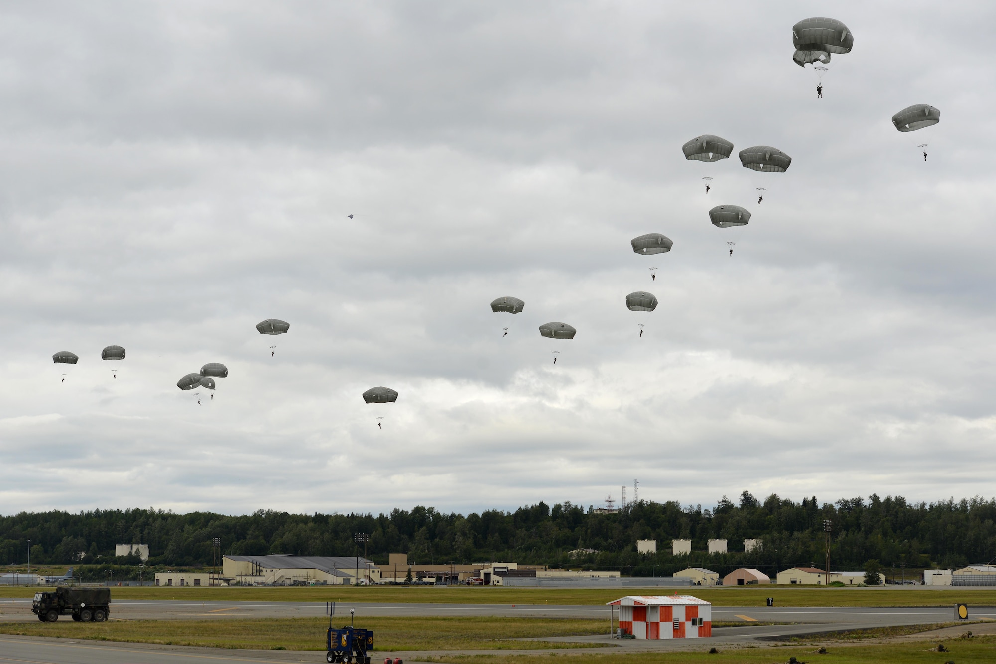 The Joint Base Elmendorf-Richardson U.S. Army and Air Force work together to demonstrate infiltration, seizing and commanding an airfield with Army paratroopers and the C-17 Globemaster during the Arctic Thunder Open House. This bienneial event hosted by Joint Base Elmendorf-Richardson, Alaska, is historically the largest two-day event in the state and one of the premier aerial demonstrations in the world. The event features more than 40 key performers and ground acts to include the JBER joint forces, U.S. Air Force F-22, and U.S. Navy Blue Angels demonstrations teams, July 30-31. (U.S. Air Force photo by Airman 1st Class Christopher R. Morales)