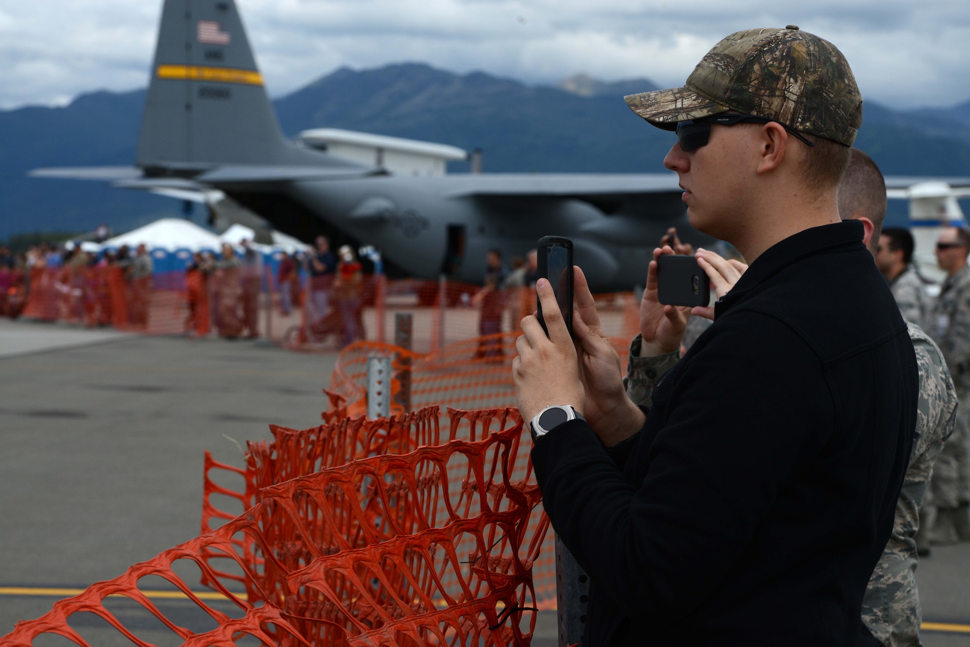 Gregory Decker, a weapons systems coordinator with 3rd Maintenance Group at JBER takes photos of the U.S. Navy Flight Demonstration Squadron, the Blue Angels take-off during Arctic Thunder Special Needs and Family Day, July 29, 2016. JBER will open the doors to the public, showcasing more than 40 key performers and ground acts to include the JBER joint forces, U.S. Air Force F-22, and U.S. Navy Blue Angels demonstrations teams. (U.S Air Force photo by Airman 1st Class Javier Alvarez)