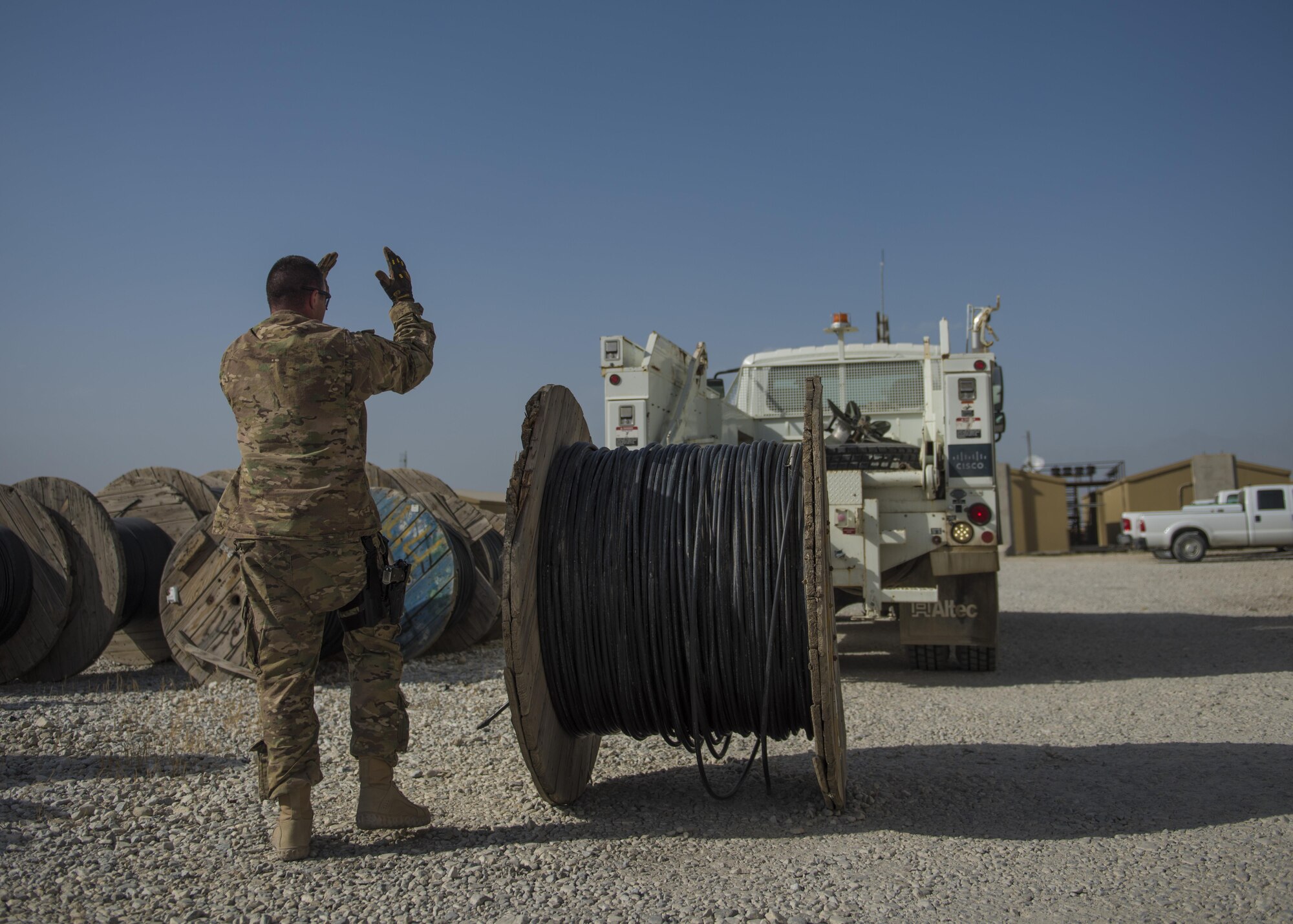 Staff Sgt. Corey Blanar, 455th Expeditionary Communications Squadron, cable and antenna maintenance noncommissioned officer in charge, guides a cable reel truck, Bagram Airfield, Afghanistan, July 30, 2016. Cable reel trucks are used to transport cables to installation sites. The cable team is working to expand network capabilities on the south side of the base. (U.S. Air Force photo by Senior Airman Justyn M. Freeman)