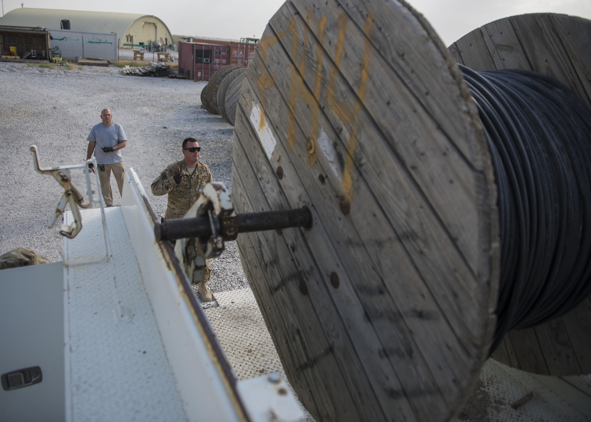 Staff Sgt. Corey Blanar, 455th Expeditionary Communications Squadron, cable and antenna maintenance noncommissioned officer in charge and Patrick Casket, 455th Expeditionary Communications Squadron, cable and antenna maintenance technician, make sure the cable reel is aligned on a truck, Bagram Airfield, Afghanistan, July 30, 2016. Cable reel trucks are used to transport cables to installation sites. The cable team is working to expand network capabilities on the south side of the base. (U.S. Air Force photo by Senior Airman Justyn M. Freeman)