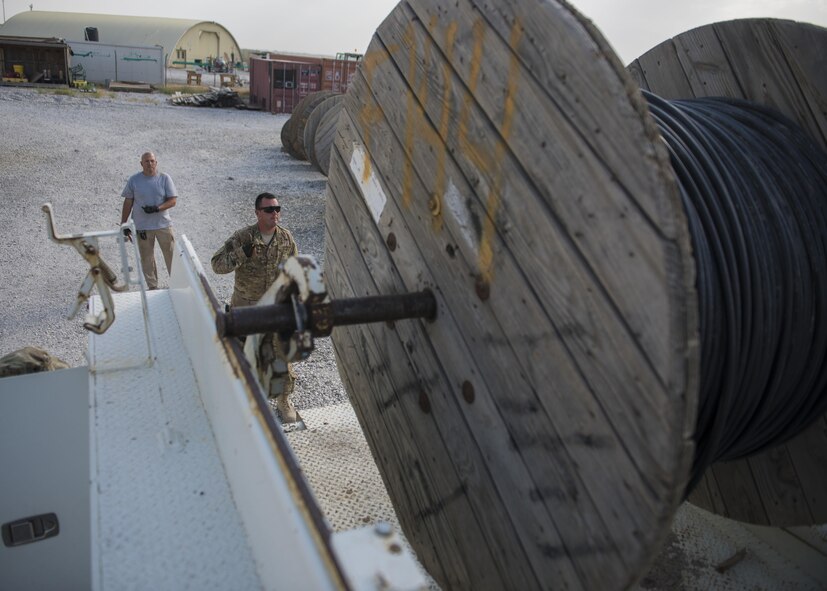 Staff Sgt. Corey Blanar, 455th Expeditionary Communications Squadron, cable and antenna maintenance noncommissioned officer in charge and Patrick Casket, 455th Expeditionary Communications Squadron, cable and antenna maintenance technician, make sure the cable reel is aligned on a truck, Bagram Airfield, Afghanistan, July 30, 2016. Cable reel trucks are used to transport cables to installation sites. The cable team is working to expand network capabilities on the south side of the base. (U.S. Air Force photo by Senior Airman Justyn M. Freeman)
