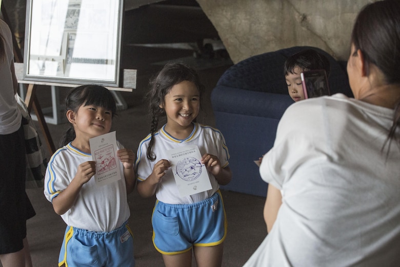 Students of Iwakuni-Kawashimo Kindergarten pose with zero hangar stamps they received during a school visit at Marine Corps Air Station Iwakuni, Japan, July 21, 2016. The school visit is a time honored tradition between the base and the local community and holds a lasting memory with the visiting students. (U.S. Marine Corps photo by Cpl. Nathan Wicks)