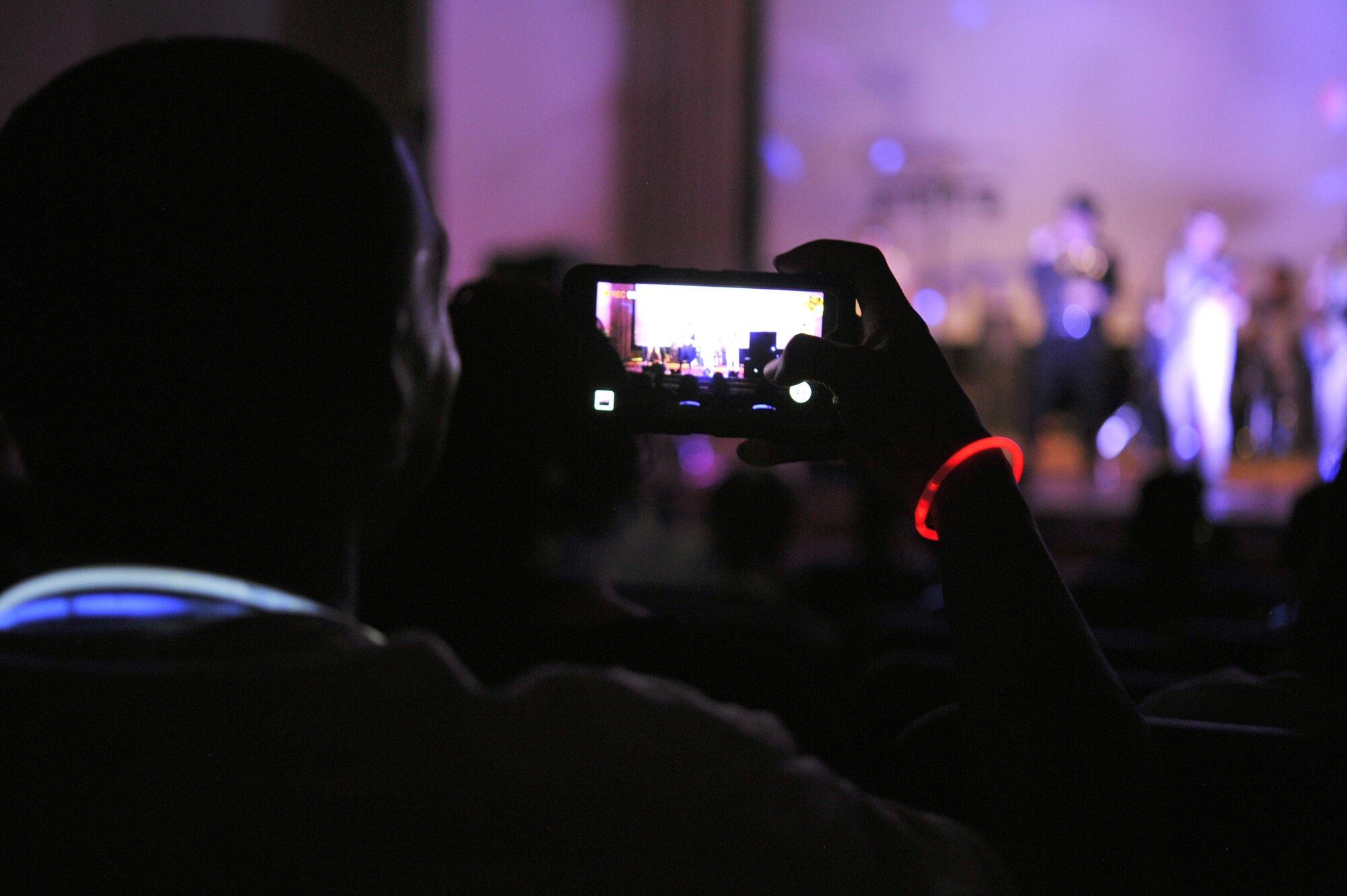 A member of the 386th Air Expeditionary Wing takes photos during a live performance from the band “Pop Rocks” at an undisclosed location in Southwest Asia, May 29, 2016. Rockfest XIV was organized and led by the 386th Expeditionary Force Support Squadron as an end-of-tour celebration for 386 AEW Marauders. (U.S. Air Force photo by Senior Airman Zachary Kee)