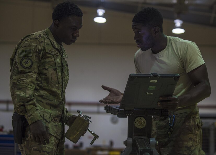 Staff Sgt. Quinton Glover (right) and Senior Airman Davon Thompson (left), 455th Expeditionary Aircraft Maintenance Squadron aerospace ground equipment technicians, review the technical order while repairing an aircraft tow bar at Bagram Airfield, Afghanistan, May 31, 2016. AGE Airmen service, inspect, troubleshoot, repair, and perform preventative maintenance on ground support equipment. (U.S. Air Force photo by Senior Airman Justyn M. Freeman)