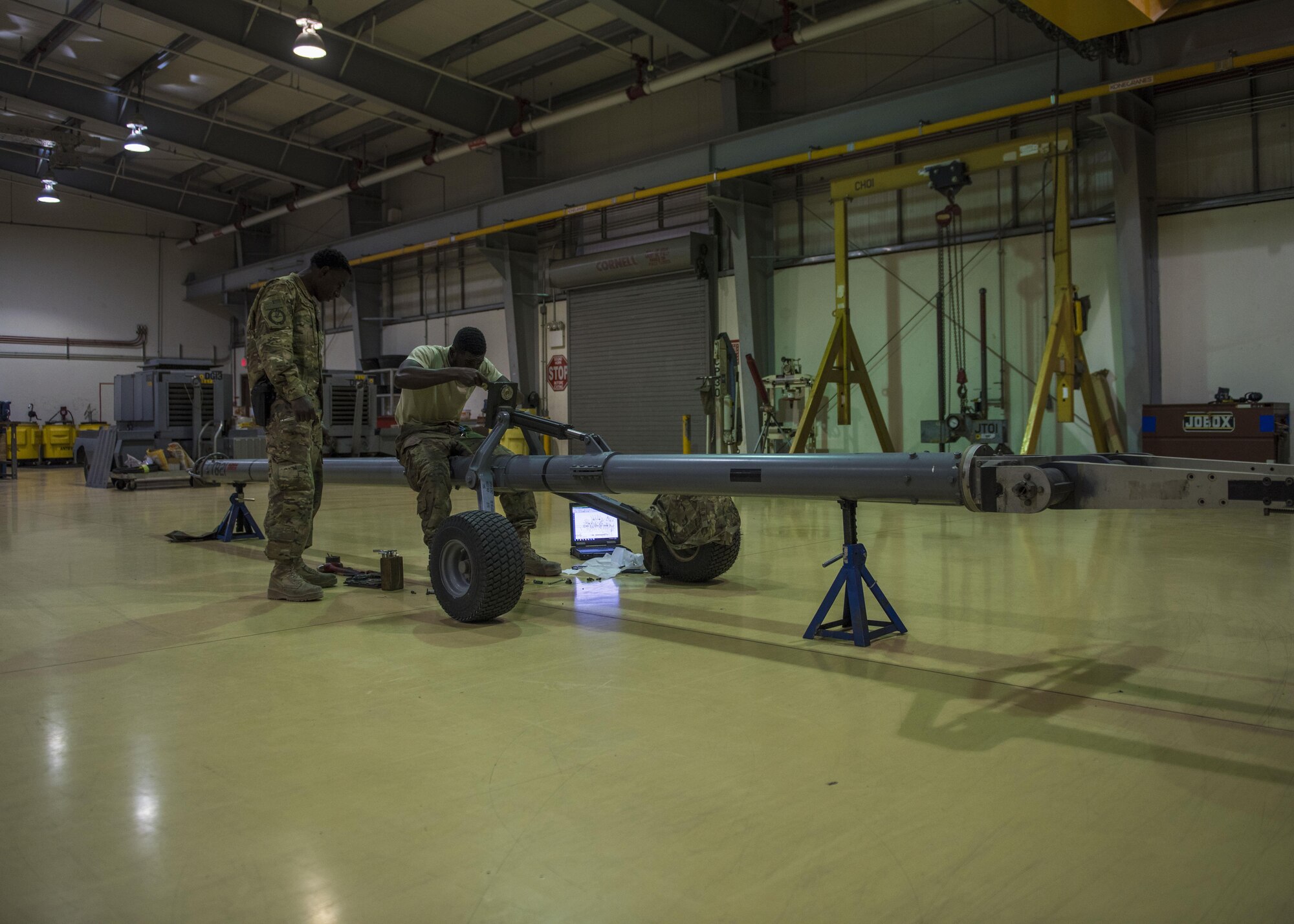 Staff Sgt. Quinton Glover and Senior Airman Davon Thompson, 455th Expeditionary Aircraft Maintenance Squadron aerospace ground equipment technician, repair an aircraft tow bar at Bagram Airfield, Afghanistan, May 31, 2016. AGE Airmen service, inspect, troubleshoot, repair, and perform preventative maintenance on ground support equipment. (U.S. Air Force photo by Senior Airman Justyn M. Freeman)