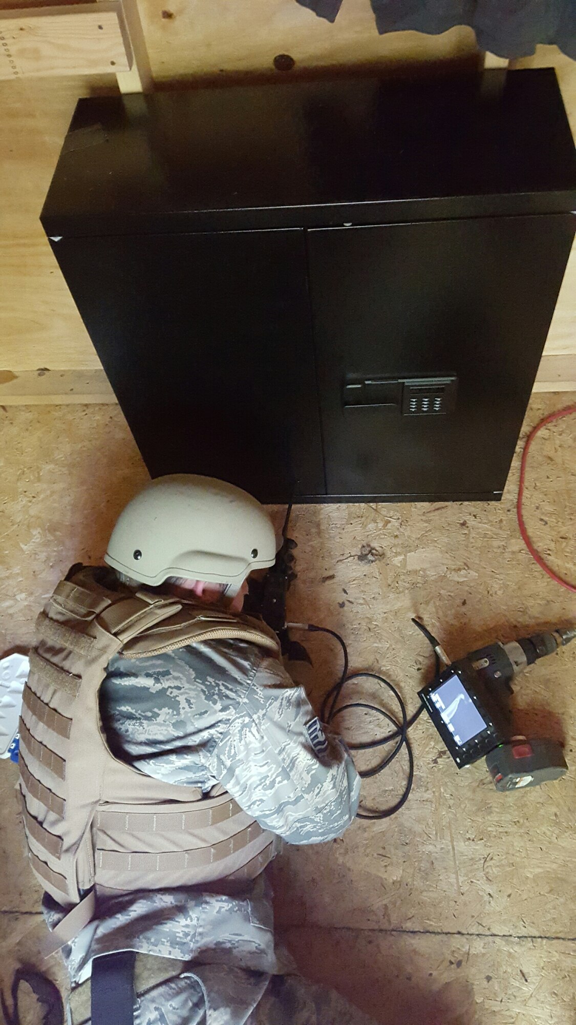 Tech. Sgt. Aaron Clark, EOD team leader, 914th Civil Engineer Squadron, uses a fiberscope to look inside a cabinet that he believes is booby-trapped with an Improvised Explosive Device. He performed this action as part of Ravens Challenge, an inter-agency IED training event held from May 16-20, 2016 in Oriskany, NY. (U.S. Photo by Tech. Sgt. Adam Clement/released)