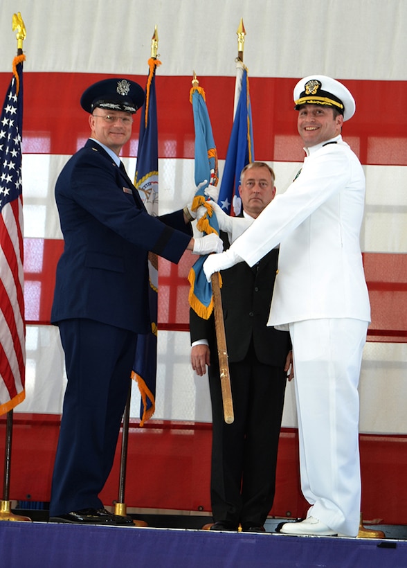 Brig. Gen. Allan Day, Defense Logistics Agency Aviation commander, holds the DLA flag with Navy Cmdr. Daniel Bessman, the new DLA Aviation at  Jacksonville site commander, during a change of command ceremony May 25, 2016 at Hangar 117, Naval Air Station Jacksonville, Florida. Bessman took command from retiring Navy Cmdr. Maurice Meagher, III.
