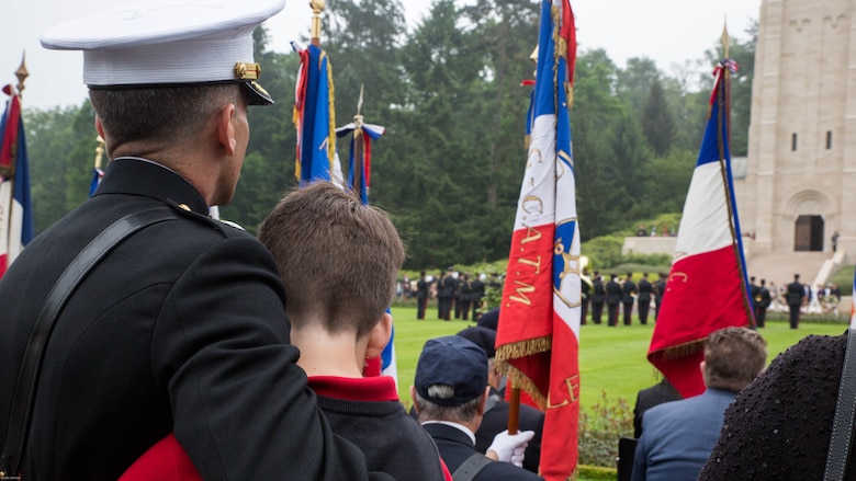 A U.S. Marine Lt. Col. and his  son enjoy the French Army band during a Memorial Day ceremony in which U.S. Marines performed alongside the French Army at the Aisne-Marne American Memorial Cemetery in Belleau, France, May 29, 2016. The French and the Americans gathered together, as they do every year, to honor those service members from both countries who have fallen in WWI, Belleau Wood and throughout history, fighting side by side. The Marines also remembered those they lost in the Battle of Belleau Wood 98 years ago.