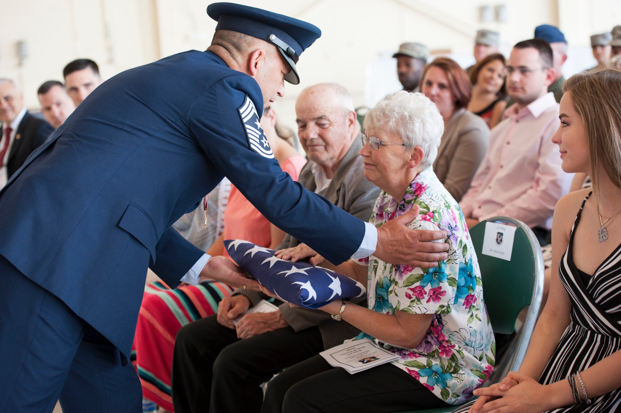 U.S. Air Force Chief Master Sgt. David Kelch, 23d Wing command chief, presents his retirement flag to his mother during his retirement ceremony at Moody Air Force Base, Ga., May 26, 2016. As the command chief, Kelch served as the liaison between the wing commander and the 23d WG's more than 6,000 military and civilian personnel. (U.S. Air Force photo by Andrea Jenkins/Released)