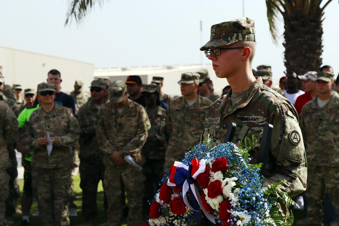 Pvt. Zachary Zavetsky, an U.S. Army Central Soldier from Leland, NC, waits to present the wreath during the Memorial Day service hosted by USARCENT and the Area Support Group – Kuwait, May 30, 2016 at Camp Arifjan, Kuwait. The wreath-laying ceremony honors fallen Servicemembers. (Photo by Spc. Angela Lorden/Released)