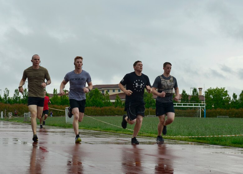 Participants run around the base track during the Memorial Day “Murph” challenge, May 30, 2016, at Aviano Air Base, Italy. The workout, named after fallen U.S. Navy SEAL Lt. Michael Murphy, included a 1-mile run, followed by 100 pull-ups, 200 push-ups, 300 squats, and another 1-mile run to finish. (U.S. Air Force photo by Airman 1st Class Cary Smith/Released)