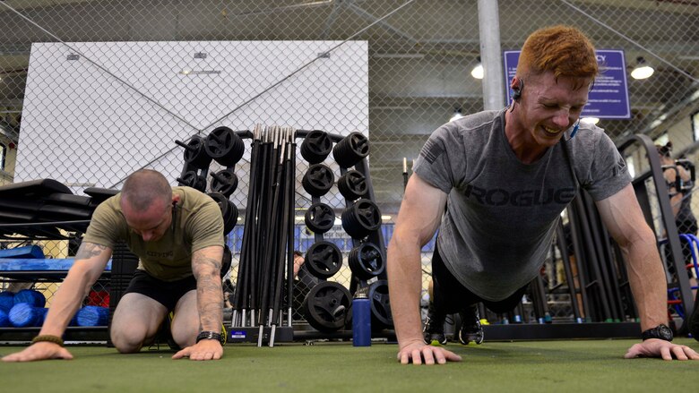 Senior Airmen Joshua Cavalancia, 31st Munitions Squadron precision guided munitions crew member, and Daniel Guilfoyle, 31st MUNS munition systems equipment maintenance crew member, perform push-ups during the Memorial Day “Murph” challenge, May 30, 2016, at Aviano Air Base, Italy. The participants completed the challenge to pay tribute to fallen service members. (U.S. Air Force photo by Airman 1st Class Cary Smith/Released)