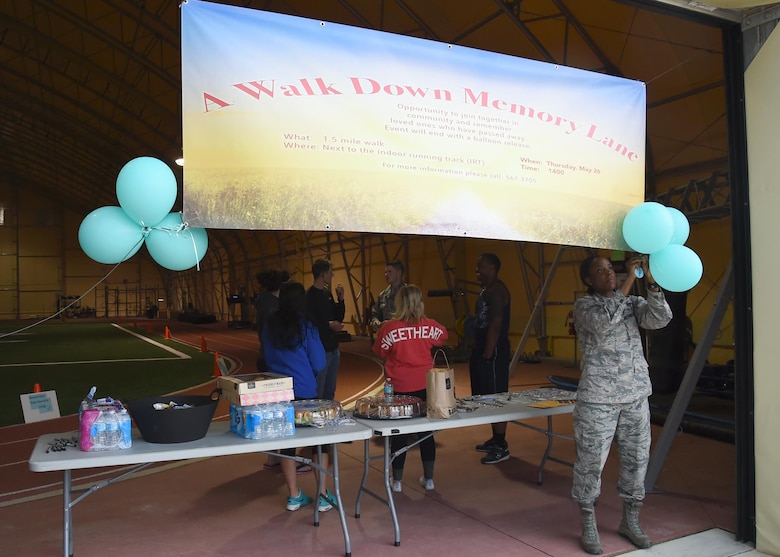 Chaplain (Capt.) Jennifer Ray, 50th Space Wing, ties balloons to a sign before “A walk down memory lane” event in the indoor running track, at Schriever Air Force Base, Colorado, Thursday, May 26, 2016. The event was an opportunity for the Schriever community to come together and remember loved ones who have passed away. (U.S. Air Force photo/Staff Sgt. Matthew Coleman-Foster)