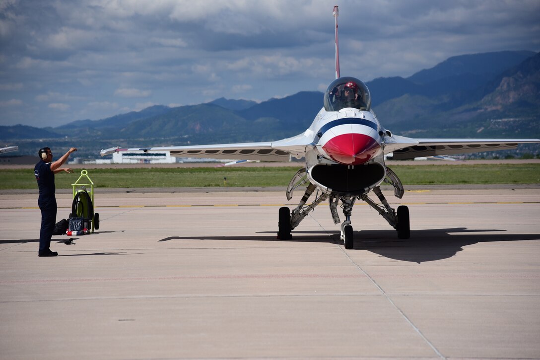 Capt. Ryan Bodenheimer, U.S. Air Force Thunderbird’s left wing, and one of his dedicated crew chiefs exchange hand signals during preflight preparations on Peterson Air Force Base, Colo., May 31, 2016. The Thunderbirds are gearing up to perform a flyover at the United States Air Force Academy graduation. (U.S. Air Force photo by Staff Sgt. Amber Grimm)