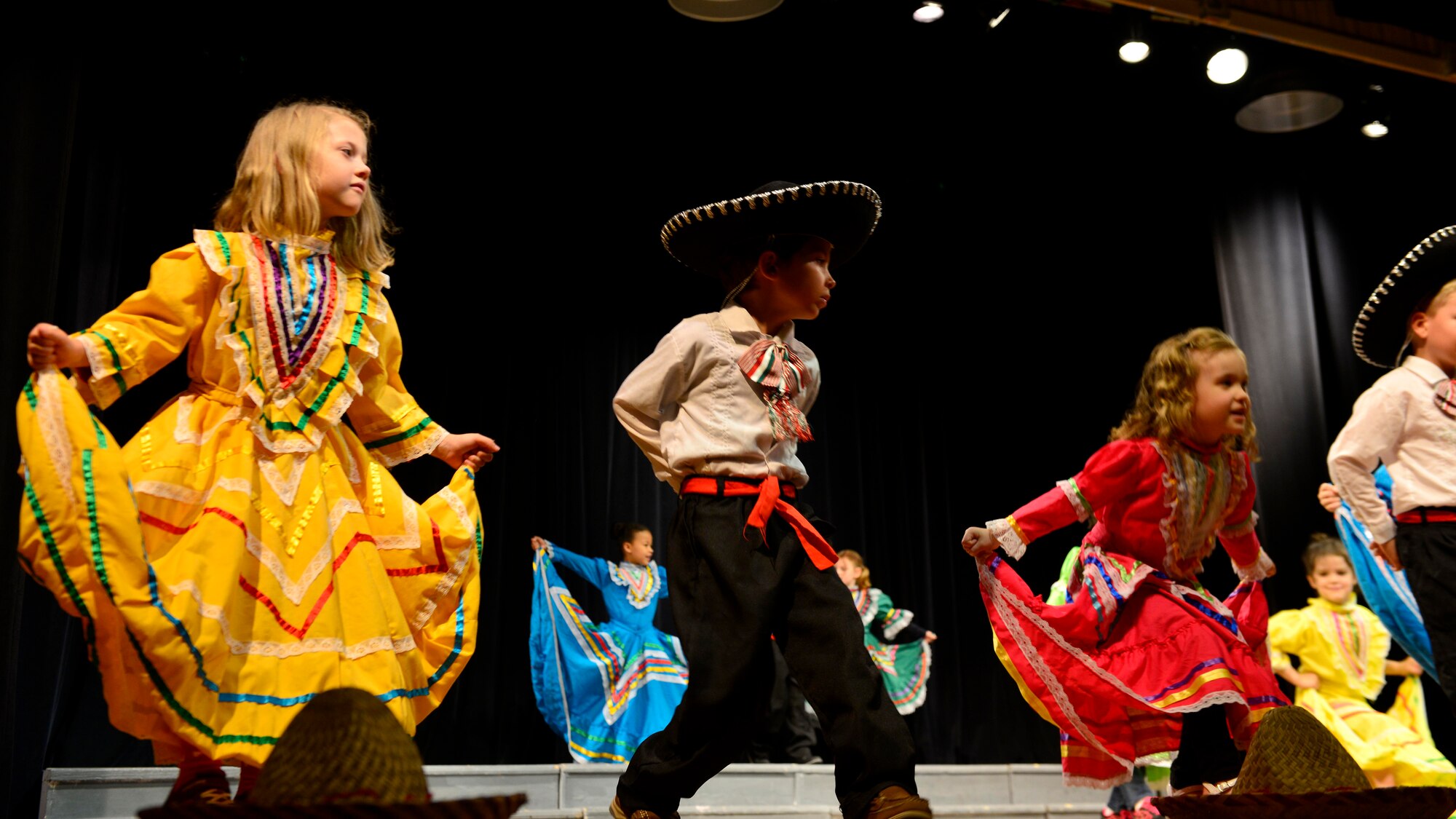 Aviano Elementary School kindergarteners perform the Mexican hat dance during the end-of-year celebration, June 1, 2016, at Aviano Air Base, Italy. Children wore authentic outfits related to the type of dance they performed. (U.S. Air Force photo by Airman 1st Class Cary Smith/Released)