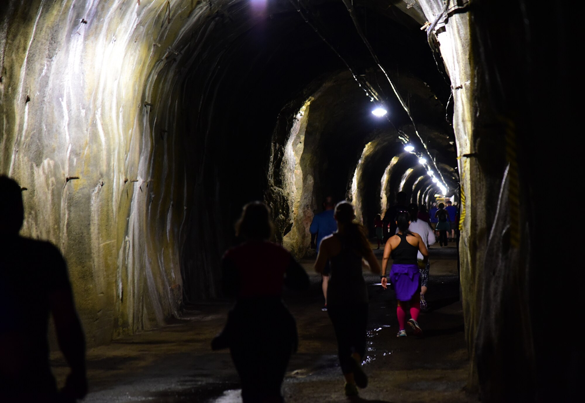 Runners travel a long stretch of dark tunnel through the heart of Cheyenne Mountain Air Force Station during the CMAFS 5k Tunnel Run/Open House May 26, 2016. The event was part of the ongoing 50th anniversary celebration of the “Americas Fortress” becoming fully operational. (U.S. Air Force photo by Staff Sgt. Amber Grimm)