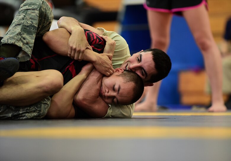 Staff Sgt. Robert Segovia, 50th Civil Engineer Squadron, places his opponent in a chokehold during the National Police Week Ground Combatives Tournament on Peterson Air Force Base, Colorado, May 17, 2016. Segovia won his weight class and brought home the gold for Team Schriever. Fifteen participants from units at Schriever and Peterson Air Force Bases, Cheyenne Mountain Air Force Station, military police from Fort Carson and a civilian off-duty officer from Denver competed in the event. (U.S. Air Force photo/Staff Sgt. Amber Grimm)