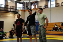 Staff Sgt. Robert Segovia, 50th Civil Engineer Squadron, is declared the winner during the National Police Week Ground Combatives Tournament held on Peterson Air Force Base, Colorado, May 17, 2016. Segovia won both matches in his weight class of 135-145 lbs. and brought home the gold for Team Schriever. (U.S. Air Force photo/Staff Sgt. Amber Grimm)