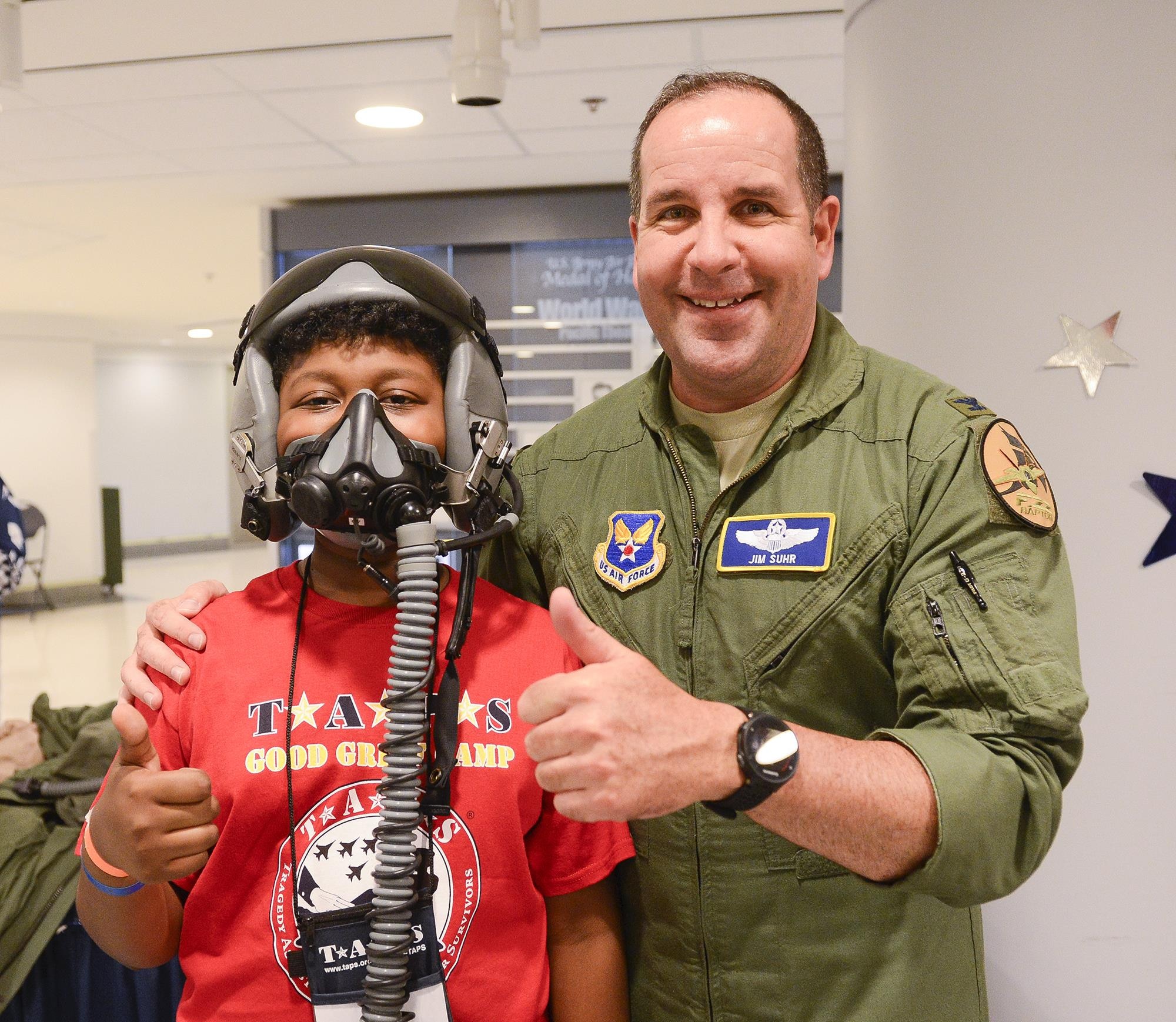 Col. Jim Suhr, an F-22 Raptor pilot, helps a child try on flight gear at the Pentagon in Washington, D.C., May 27, 2016. Defense Secretary Ash Carter and his wife Stephanie hosted more than 300 family members during family night in the Pentagon. (U.S. Air Force photo/Andy Morataya) 