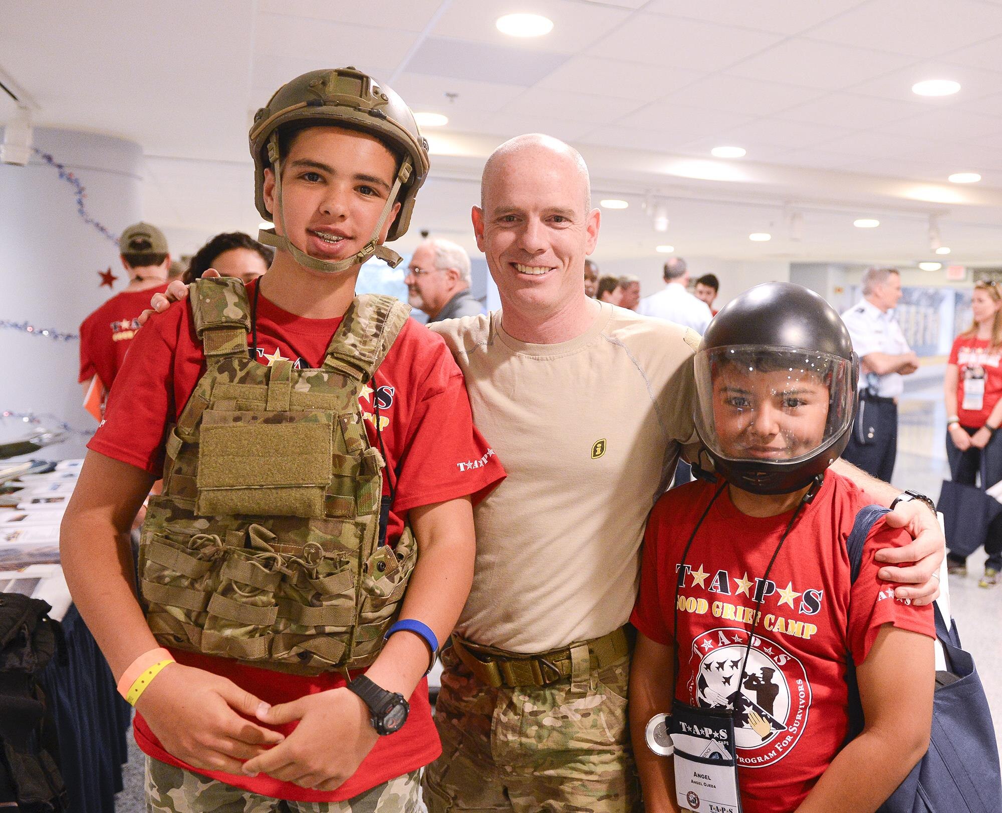 Lt. Col Chuck Bris-Bois, a combat rescue specialist, helps children try on special operations gear at the Pentagon in Washington, D.C., May 27, 2016. Defense Secretary Ash Carter and his wife Stephanie hosted more than 300 family members during family night in the Pentagon. (U.S. Air Force photo/Andy Morataya)
