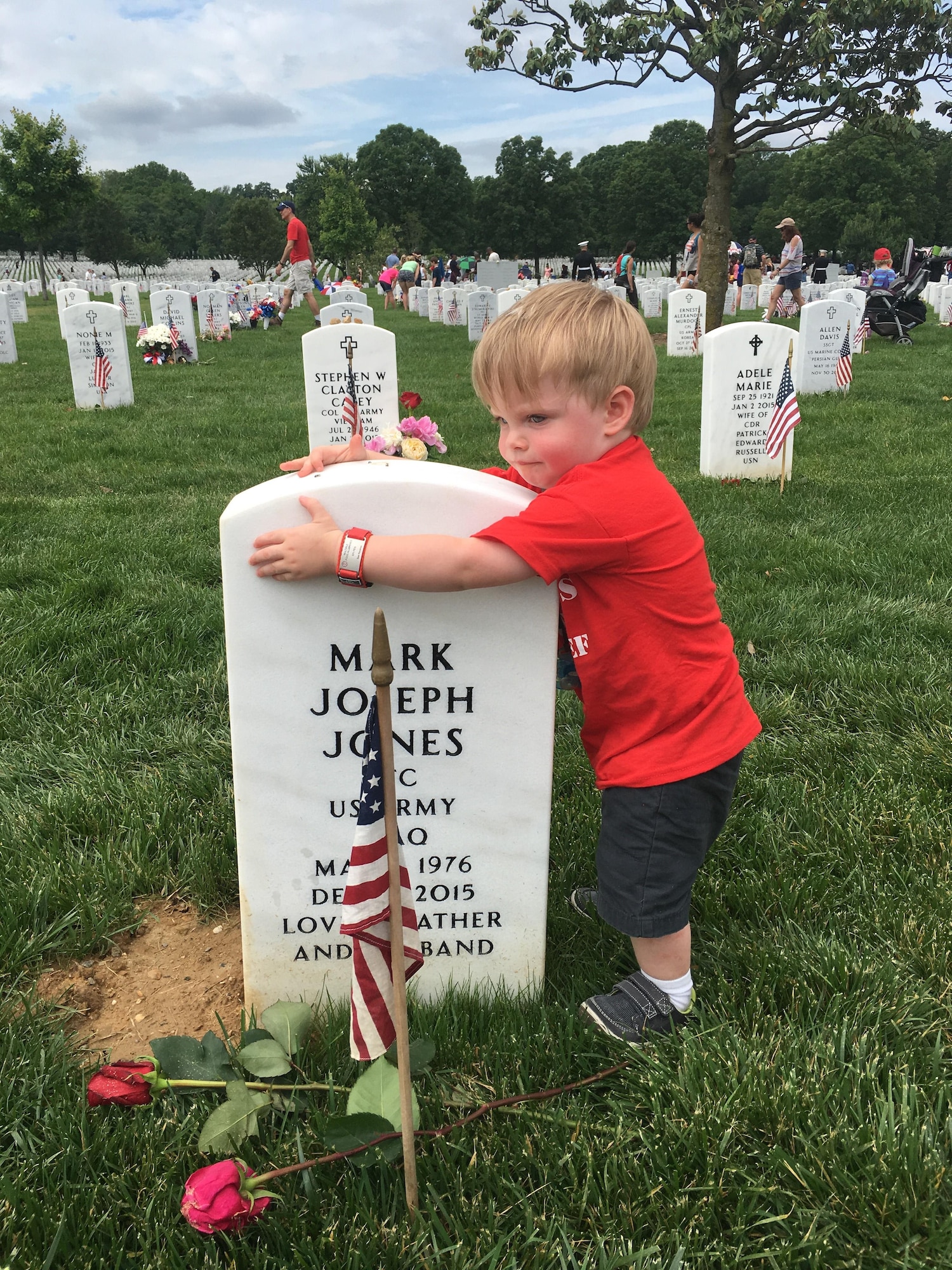Two-year-old James Jones hugs his father's headstone during a visit to Arlington National Cemetery, Va., May 30, 2016. James and his mother, Sarah Jones, participated in several events with the Tragedy Assistance Program for Survivors during the Memorial Day weekend. (Courtesy photo/Sarah Jones)