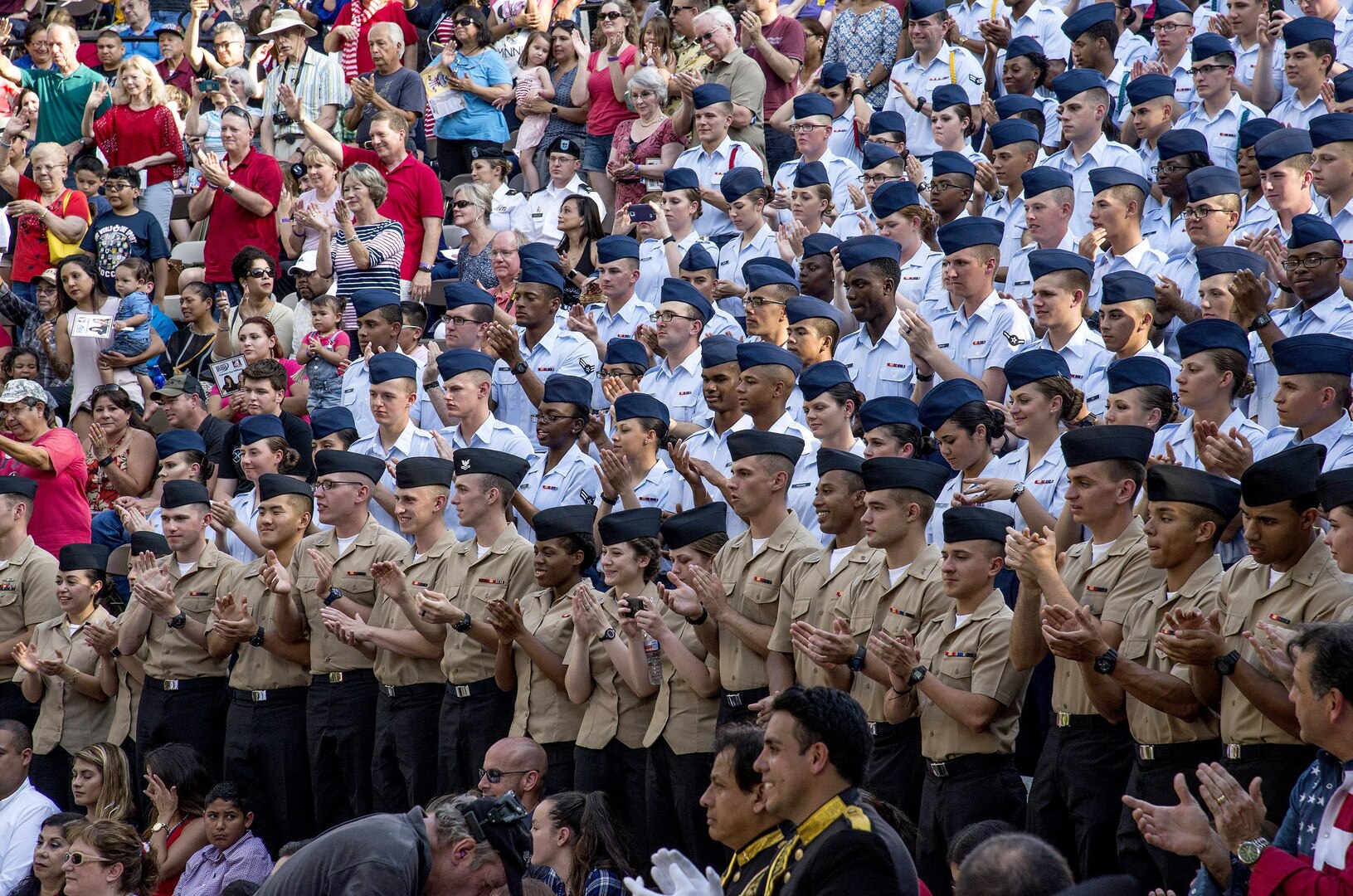Airmen and Sailors from Joint Base San Antonio cheer with members of San Antonio as floats pass by during the Armed Forces River Parade May 21 at the San Antonio Riverwalk. The parade is an annual event held in San Antonio to honor service members past and present.