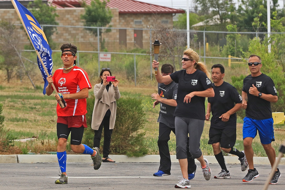 CAMP PENDLETON, Calif. -- Members of the Oceanside Police Department relay a torch to Marines from Security and Emergency Service Battalion and the Camp Pendleton Police Department during the 2016 Law Enforcement Torch Run in support of the Special Olympics, June 1. Col. Reginald L. Hairston, commanding officer of SES Bn., Marine Corps Base Camp Pendleton, Marine Corps Installations – West, received the Special Olympics torch from runners of the Oceanside Police Department at the Camp Pendleton Main Gate. SES Bn. Marines then relayed the torch and ran it 17 miles to the Orange County Sheriff’s Police Department in San Clemente.
