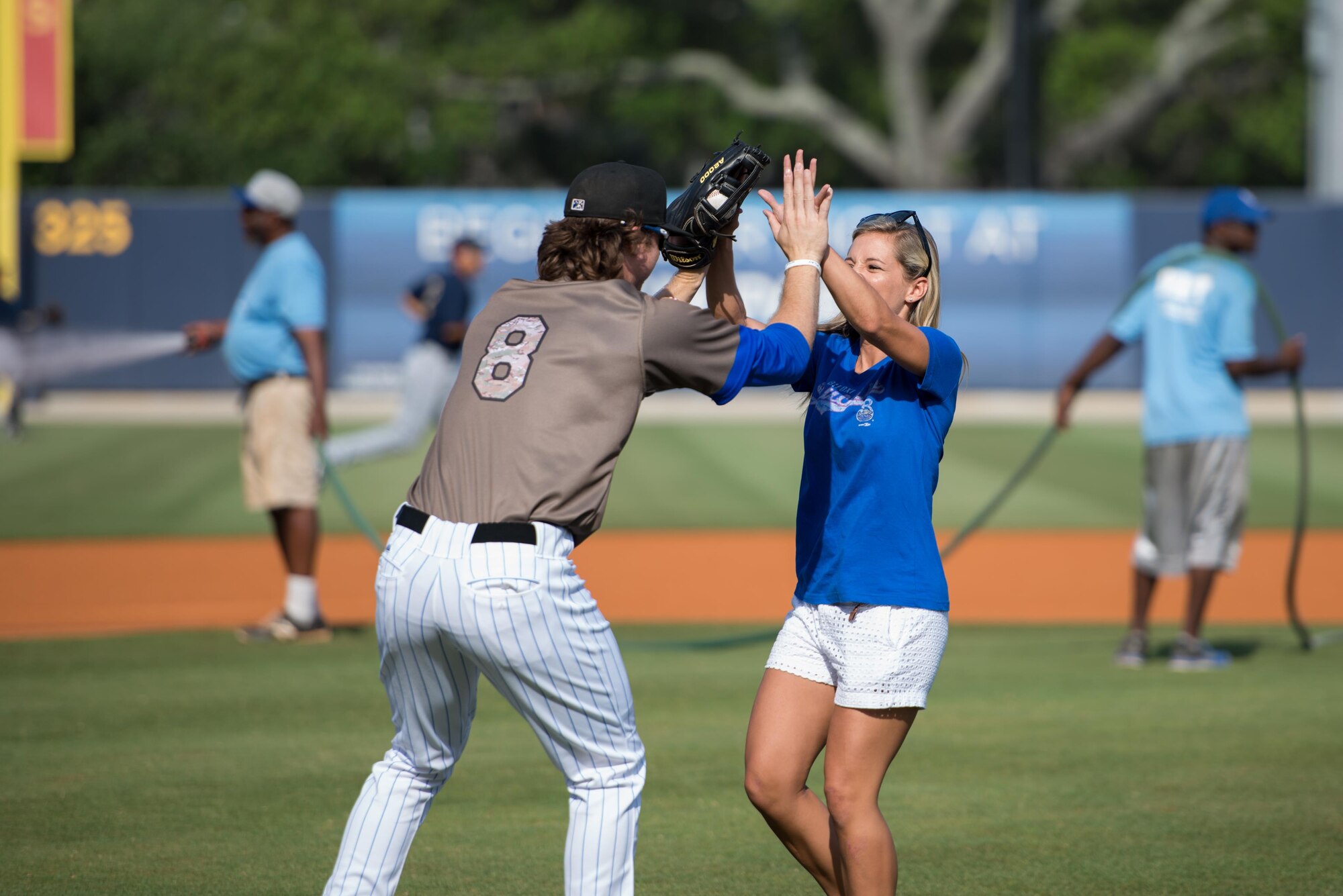 Second Lt. Brianna Wilson, 81st Contracting Squadron contracting specialist, high-fives Brett Phillips, Biloxi Shuckers Minor League Baseball outfielder, after throwing the first pitch of the game at MGM Park during the Shuckers’ Military Appreciation Game May 29, 2016, Biloxi, Miss. The Keesler Honor Guard also participated in the event to help honor local military members. (U.S. Air Force photo by Marie Floyd)