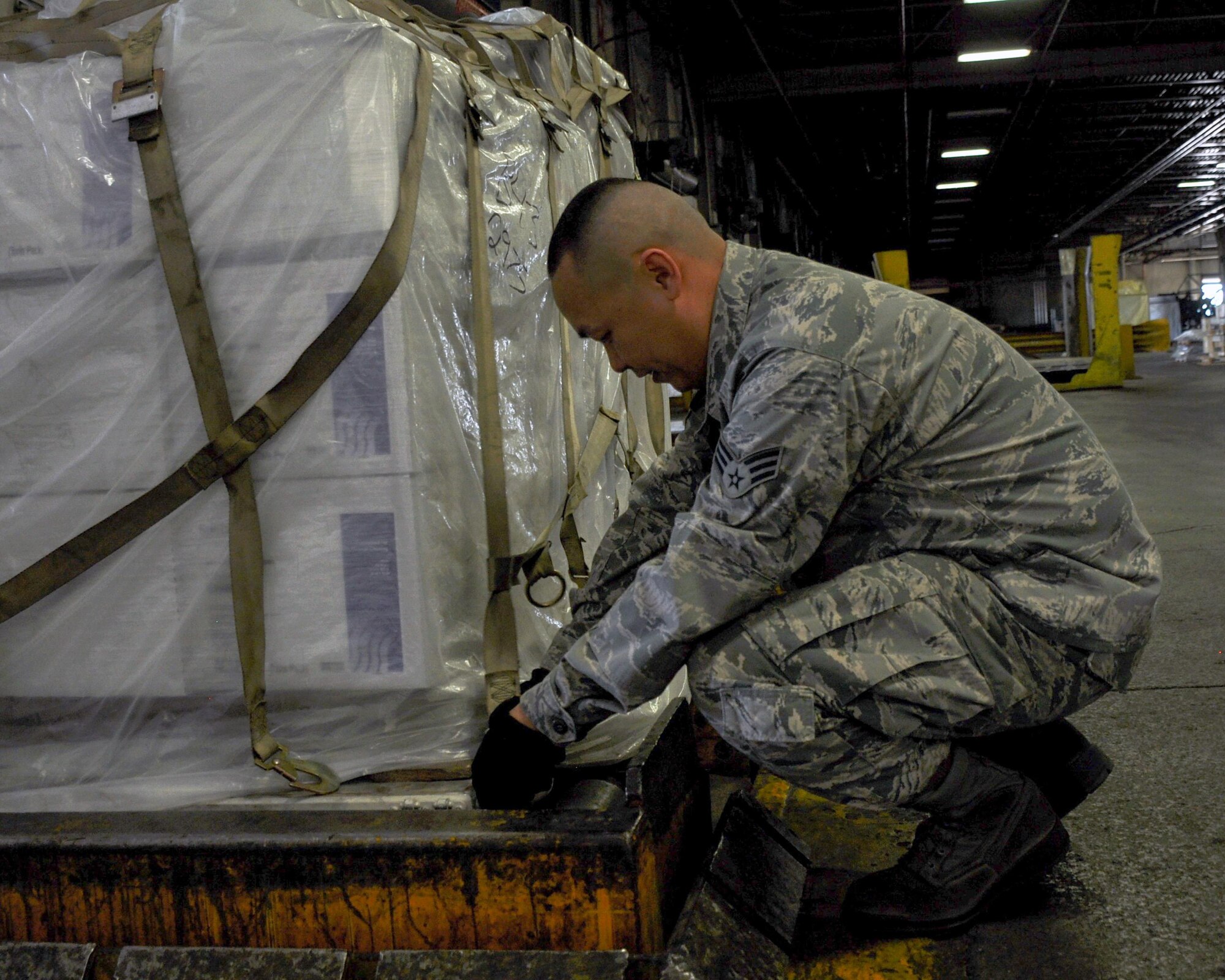 Senior Airman Maximilianair Lee, 55th Aerial Port Squadron cargo, secures cargo to a pallet April 16, 2016 at the Travis Air Force Base flightline. (U.S. Air Force photo/Staff Sgt. Madelyn Brown)