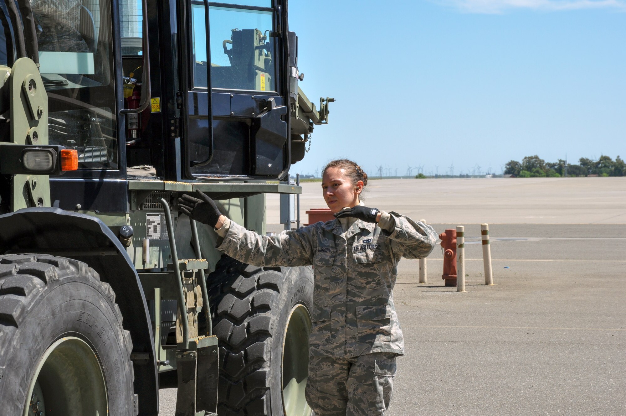 Senior Airman Catherine Lubbe, 55th Aerial Port Squadron ramp services, spots a 10K all terrain forklift, driven by Staff Sgt. Daniel Dayoan, April 16, 2016 on the Travis Air Force Base flightline.  (U.S. Air Force photos/Staff Sgt. Madelyn Brown).