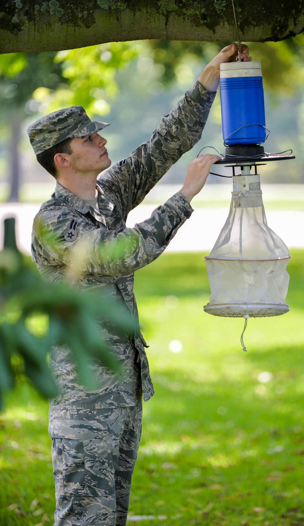 Airman 1st Class Cody Moss, 2nd Aerospace Medicine Squadron public health technician, hangs a mosquito trap at Barksdale Air Force Base, La., May 31, 2016. Technicians set traps at various locations around base, covering reported heavily populated areas with excessive mosquito activity. (U.S. Air Force photo/Senior Airman Mozer O. Da Cunha)