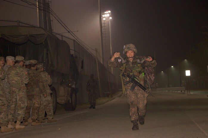 Republic of Korea Army 1st Lt. Ji Eun Jeong, a platoon leader in the 115th Mechanized Infantry Battalion, 90th Mech. Inf. Brigade, 30th Mech. Inf. Division, raises her hands in victory May 26, as she approaches the finish line of the 12-mile ruck march at Camp Casey, South Korea. Jeong is the first female ROK officer to earn the U.S. Army Expert Infantryman Badge. (U.S. Army photo by Sgt. Christopher Dennis, 1st Armored Brigade Combat Team Public Affairs, 1st Cav. Div.)