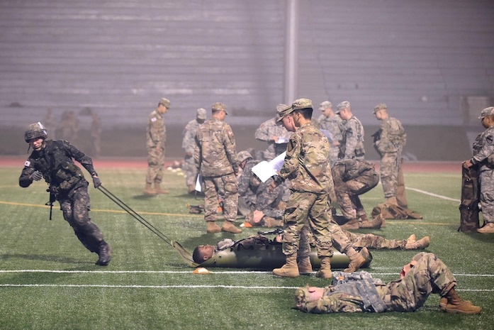 US and Republic of Korea Soldiers attempt to finish the Expert Infantryman Badge testing May 26 at “Objective Bull” in the Schoonover Bowl at Camp Casey, South Korea. The objective, which consisted of correctly evaluating a Soldier with a ‘leg wound’ and evacuating the Soldier, was the final test after a grueling five-days of evaluations that included day and night land navigation and a 12-mile foot march. (U.S. Army photo by Staff Sgt. Keith Anderson, 1st Armored Brigade Combat Team Public Affairs, 1st Cav. Div.)